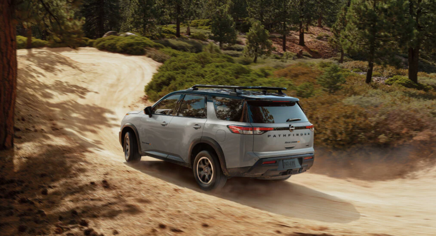 2025 Nissan Pathfinder driving on a dirt road 2025 Nissan Pathfinder driving on a dirt road